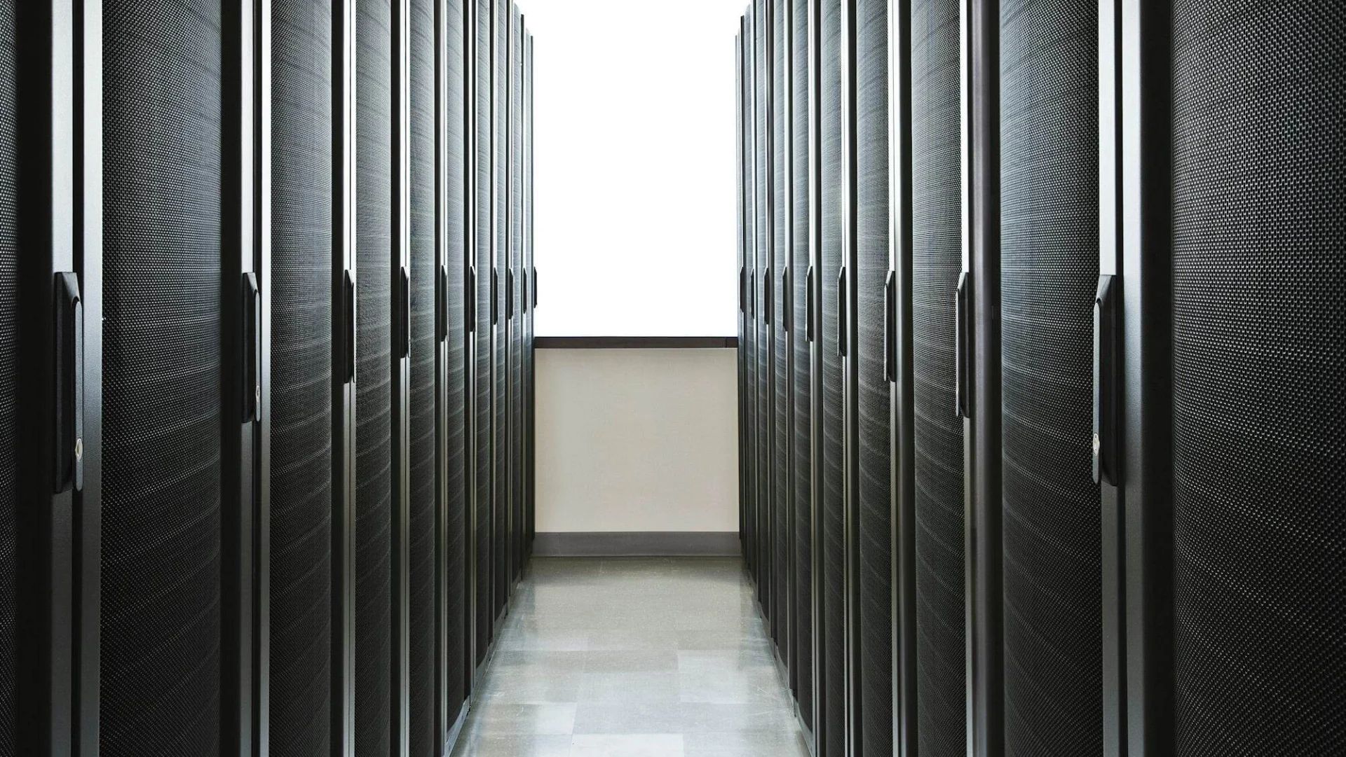 A Beginners Guide to Choosing the Right Web Hosting Provider for Your Website Storage racks aligned in a computer server room with a large window in the background.